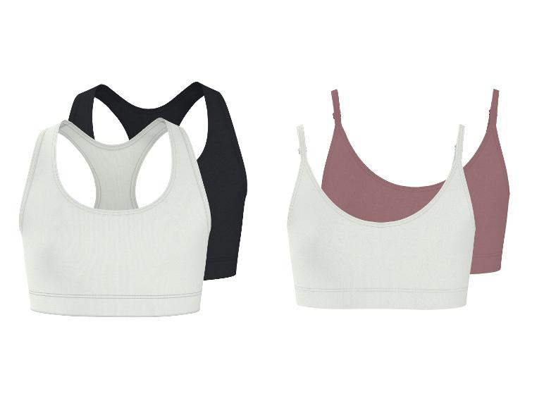 Twee sets dames sportbeha's: zwart en wit racerback, en wit en roze camisole-stijl.