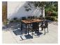 Ensemble de salle à manger d'extérieur avec table en bois et chaises en osier sur une terrasse.