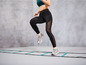 Een vrouw in sportkleding loopt over een agility ladder.