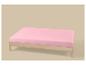 Lit simple en bois avec matelas rose clair sur fond beige