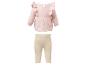 Babyoutfit met een roze top met lange mouwen en ruches en een beige geribbelde legging.