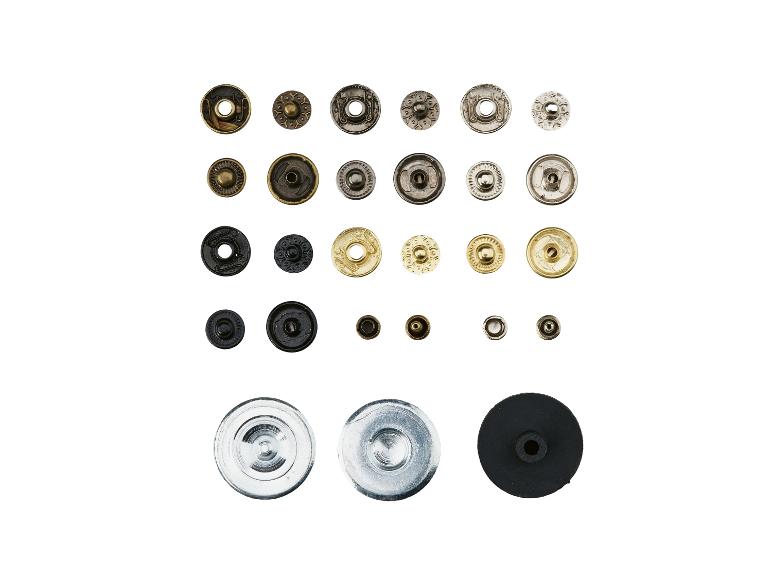 Een assortiment van diverse metalen drukknopen en knopen in verschillende maten en kleuren.