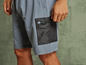 Man draagt blauwe shorts met een zak met ritssluiting.
