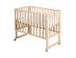 Lit bébé en bois avec literie blanche et hauteur réglable sur roulettes blanches.