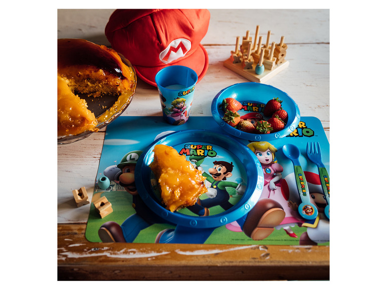 Assiette, tasse, couverts et set de table Super Mario avec gâteau et fraises.