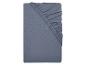 Drap-housse gris plié avec coins élastiqués.