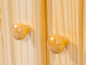 Twee houten knoppen op een houten kast.