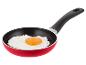 Poêle rouge avec un œuf au plat