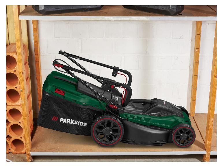 Une tondeuse à gazon Parkside verte avec un bac de ramassage noir sur une étagère en bois.