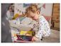 Un jeune enfant en pyjama à étoiles lit un livre avec des éléments mobiles.