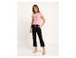Vrouw in een roze T-shirt met 'BLOOM'-opdruk en zwarte joggingbroek.