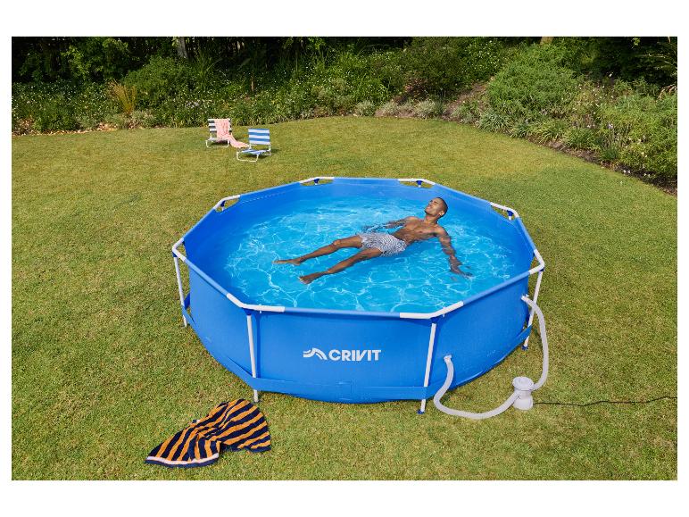 Man ontspant in een blauw zeshoekig opzetzwembad in een tuin met twee strandstoelen.