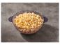 Un grand bol de pop-corn doré, posé sur une surface grise texturée.
