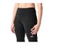 Femme en legging de sport noir avec poche latérale zippée.