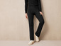 Pantalon noir en tricot et baskets blanches.