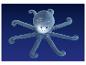 Pieuvre en peluche avec un visage lumineux et des taches blanches sur fond bleu.