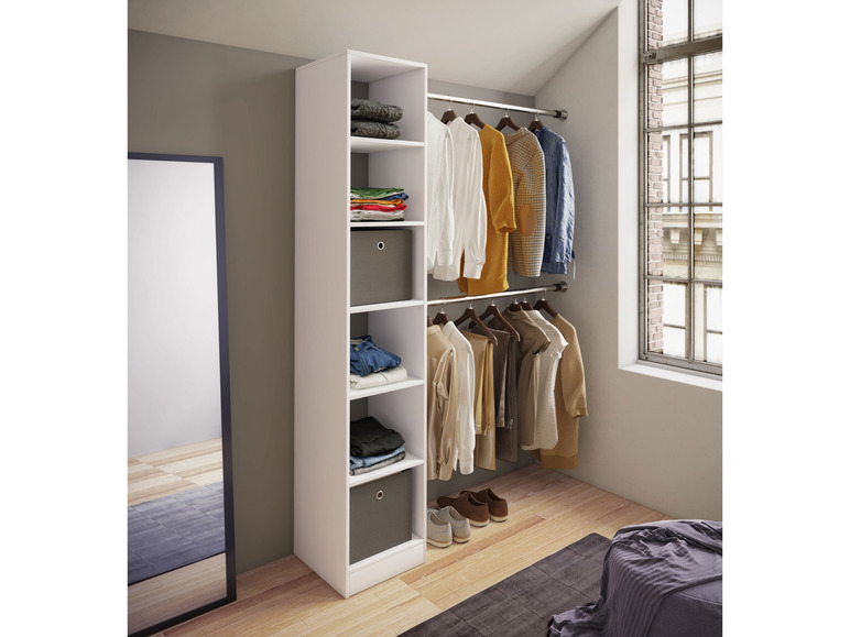 Une armoire blanche avec des étagères et une tringle à vêtements, remplie de vêtements.