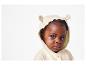 Een baby draagt een beige trui met capuchon en berenoren.