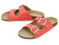 Een paar koraalkleurige sandalen met twee bandjes en metalen gespen.