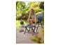 Femme posant une tablette sur un tabouret pliant à côté d'une chaise longue sur une terrasse.