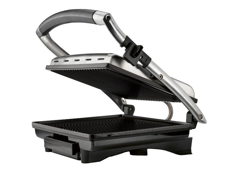 Een open elektrische grill met zwarte platen en een zilveren behuizing, op een witte achtergrond.