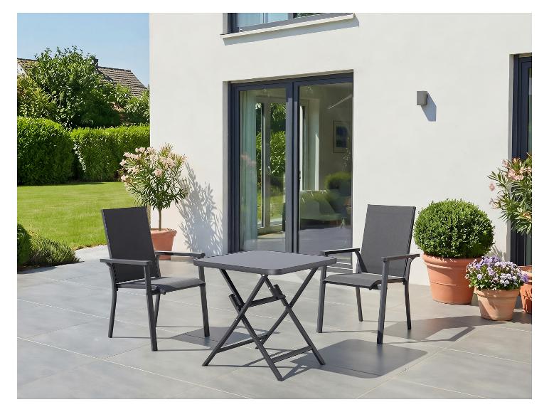 Buitenpatio met een grijze klaptafel en twee bijpassende stoelen, omringd door potplanten.