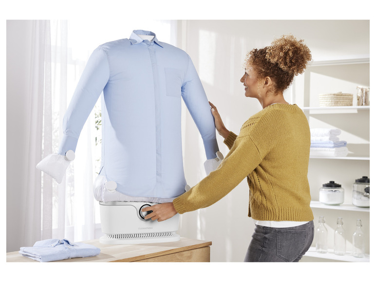 Une femme utilise un défroisseur vapeur Cleanmaxx pour repasser une chemise.