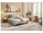 Chambre moderne avec lit beige, tables de chevet en bois, étagères et plantes.