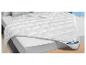 Couette blanche BeCo avec oreillers sur un lit.