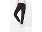 Vrouw in zwarte joggingbroek en witte sneakers, poserend met één been omhoog.