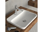 Un lavabo blanc avec un robinet chromé sur un plan en bois.