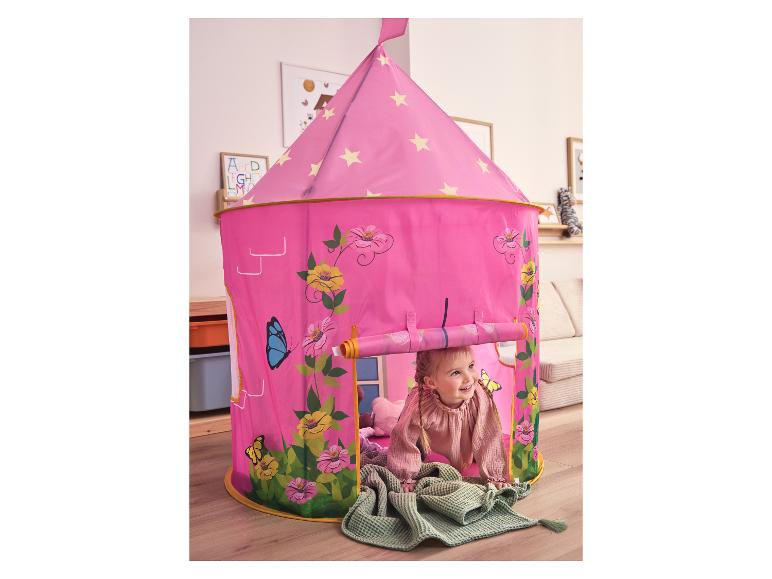 Petite fille jouant dans une tente de jeu rose avec des motifs floraux et de papillons