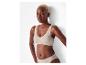Femme en soutien-gorge de sport et culotte côtelés sans couture beiges.