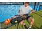 Man op padelbaan met rugzak, padelracket, bal en waterfles.