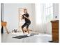 Vrouw doet squats met een kettlebell, met een weerstandsband om haar dijen.