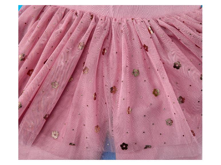 Gros plan d'une jupe en tulle rose avec des paillettes dorées et des détails floraux