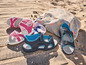Twee paar sandalen voor kinderen op een houten vlonder.