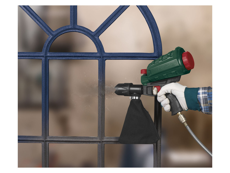 Een hand wordt getoond die een Parkside spuitpistool gebruikt om een ​​raam te schilderen.