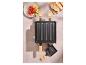 Raclette grill met groenten en brood op een tafel.