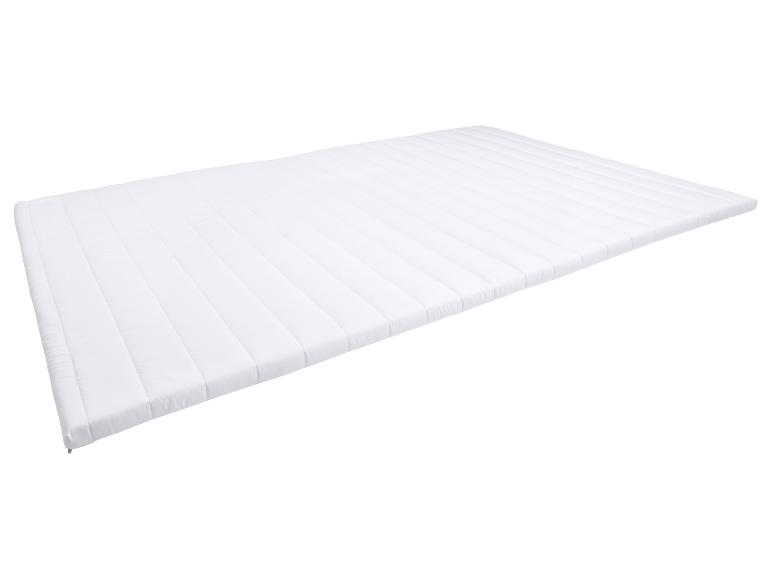 Witte gewatteerde matrastopper met horizontale stiksels.