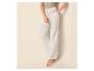 Pantalon large en mousseline blanche avec cordon de serrage et crop top vert olive, avec sandales à talons blancs.