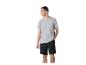 Man in grijs T-shirt en zwarte korte broek, staand en glimlachend.