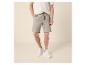 Homme en chemise tricotée à manches courtes et short en lin à cordon.