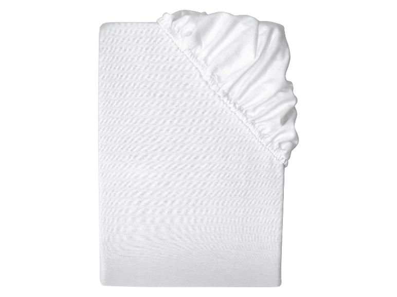 Drap-housse blanc plié sur fond blanc