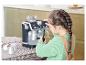 Un enfant joue avec une machine à café Delonghi.