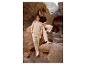 Man en vrouw in casual beige en zwarte kleding, staand tussen rotsen.