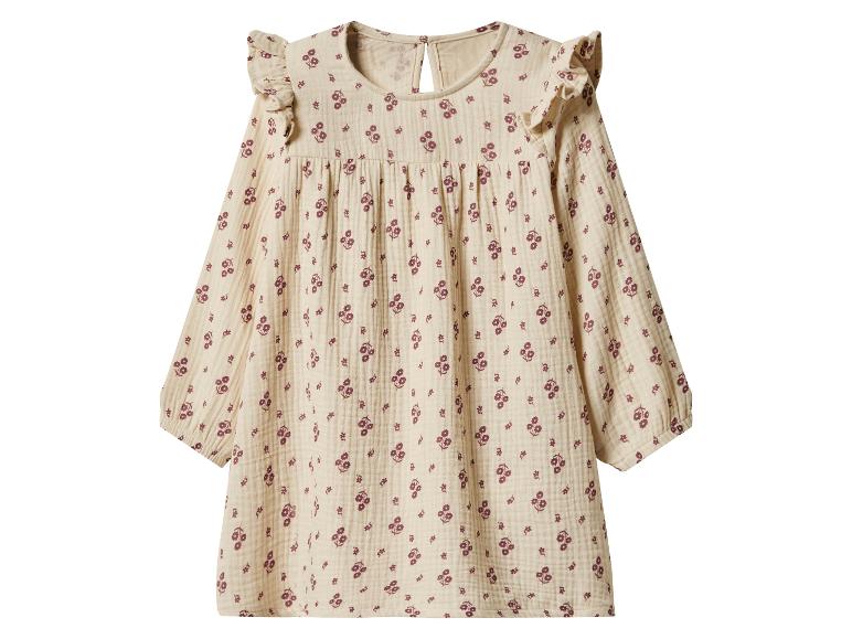 Beige jurk met lange mouwen, ruches op de schouders en een klein bloemenpatroon.