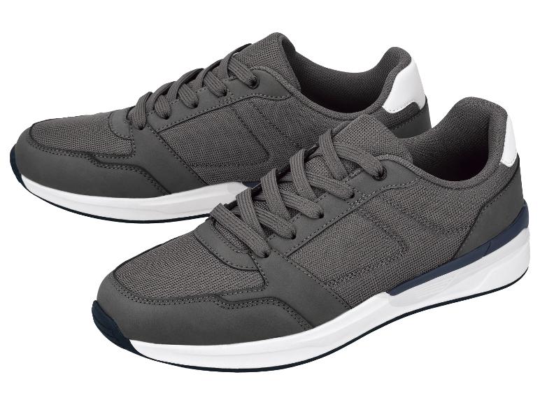 Paire de baskets grises pour hommes avec semelles blanches et bleu foncé.