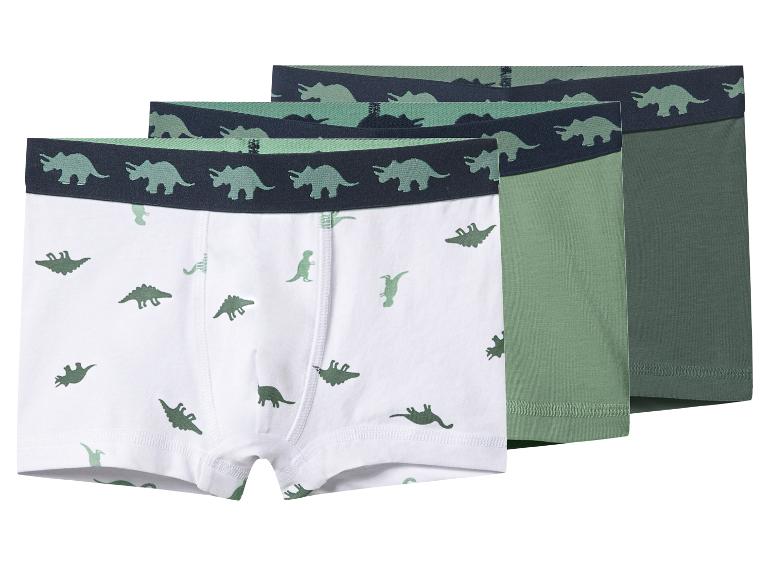 Drie jongensboxershorts met dinosauruspatroon in wit, lichtgroen en donkergroen.