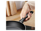 Een zwarte koekenpan met een handvat van Tefal.